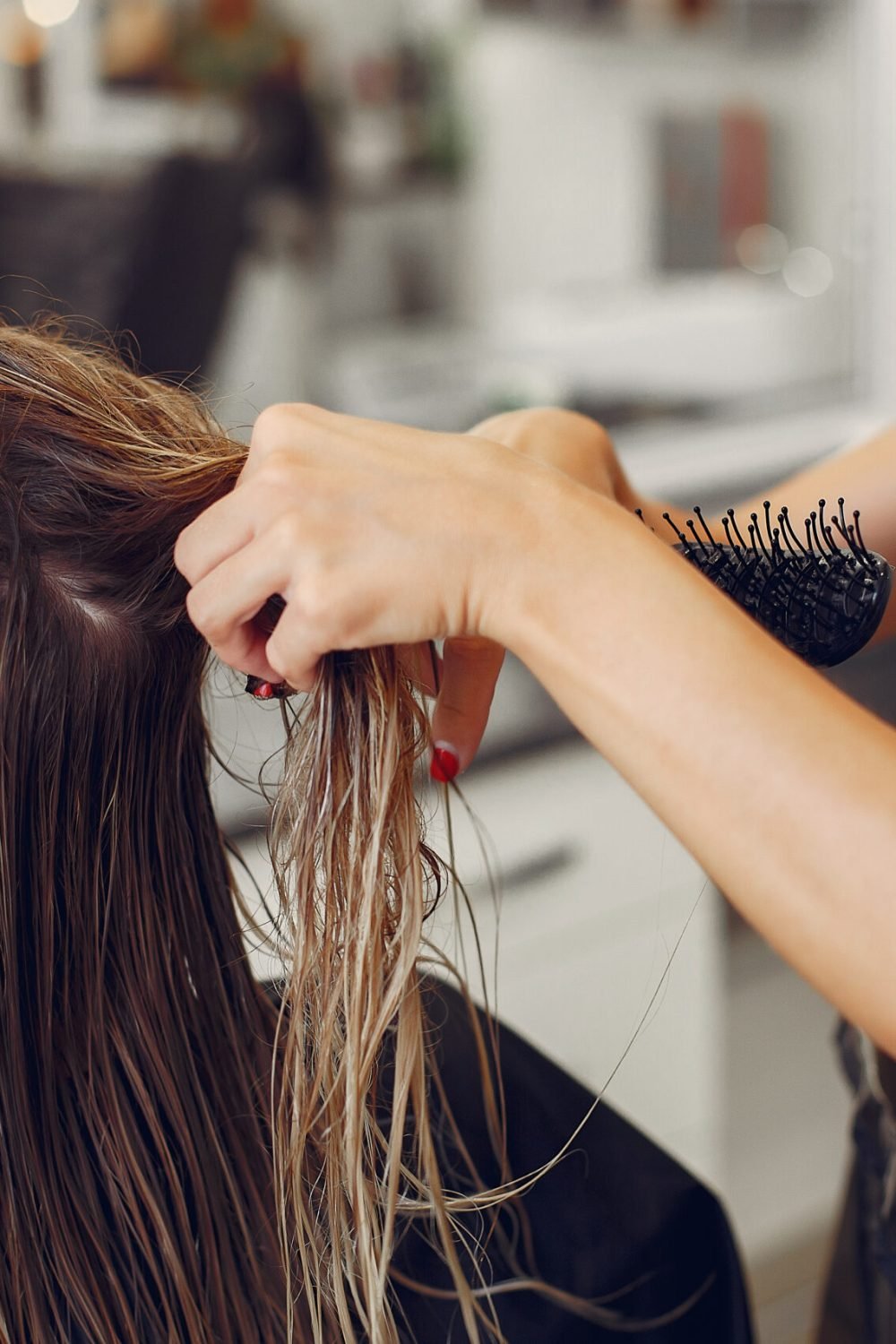 Hairdresser drying head her client. Woman in a hair salon